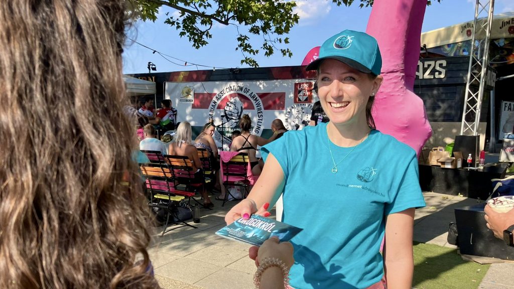 Önkéntes az Igazság a drogokról füzetet nyújt át egy strandolónak a siófoki Bodymedia Beach fesztiválon